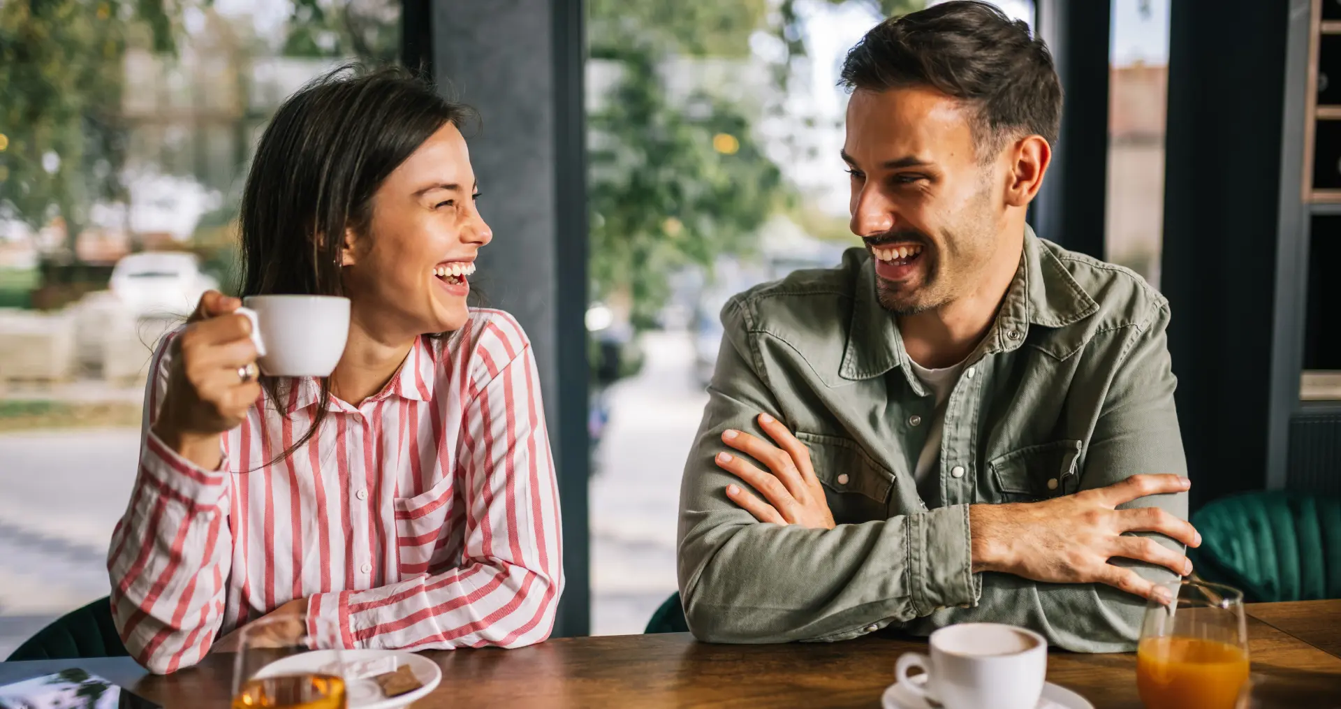 GettyImages-1650292066 (1) A man and woman sitting at a table with coffee.