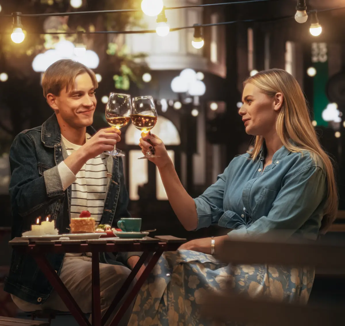 GettyImages-2150663738 A man and woman sitting at a table with wine glasses.